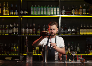 Waiter carrying tray with glasses of wine on ship's deck, mid section