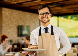 Waiter carrying tray with glasses of wine on ship's deck, mid section